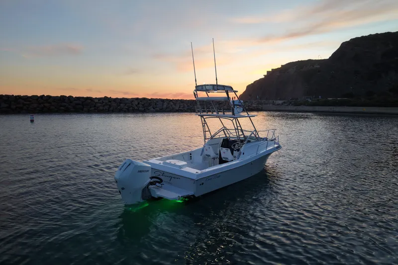 Slide: The Image of 1985 Chris-Craft 21 Scorpion Cuddy boat at sunset, illuminated on calm water. - 7