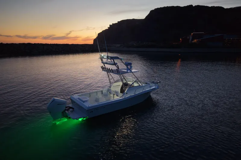 Slide: The Image of 1985 Chris-Craft 21 Scorpion Cuddy boat illuminated at sunset on calm waters. - 8