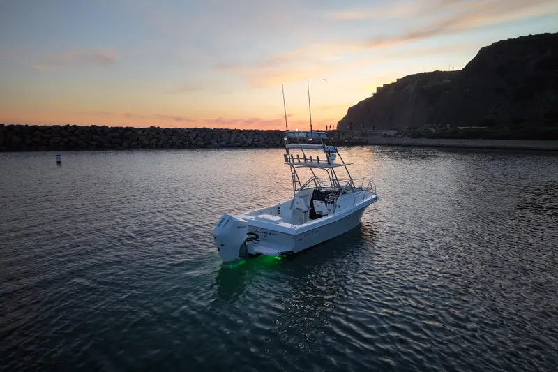 Slide: The Image of 1985 Chris-Craft 21 Scorpion Cuddy boat at sunset on calm waters. - 9
