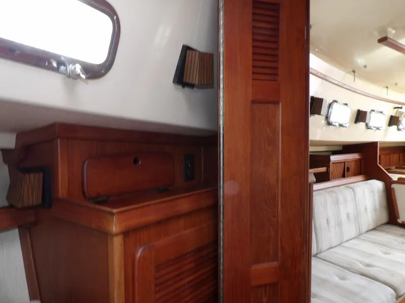 Slide: The Image of Interior of 1990 Island Packet 32 sailboat with wooden cabinetry and seating area. - 21