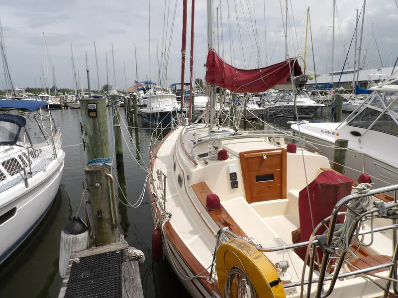 Slide: The Image of 1990 Island Packet 32 sailboat docked at a marina with other boats. - 1