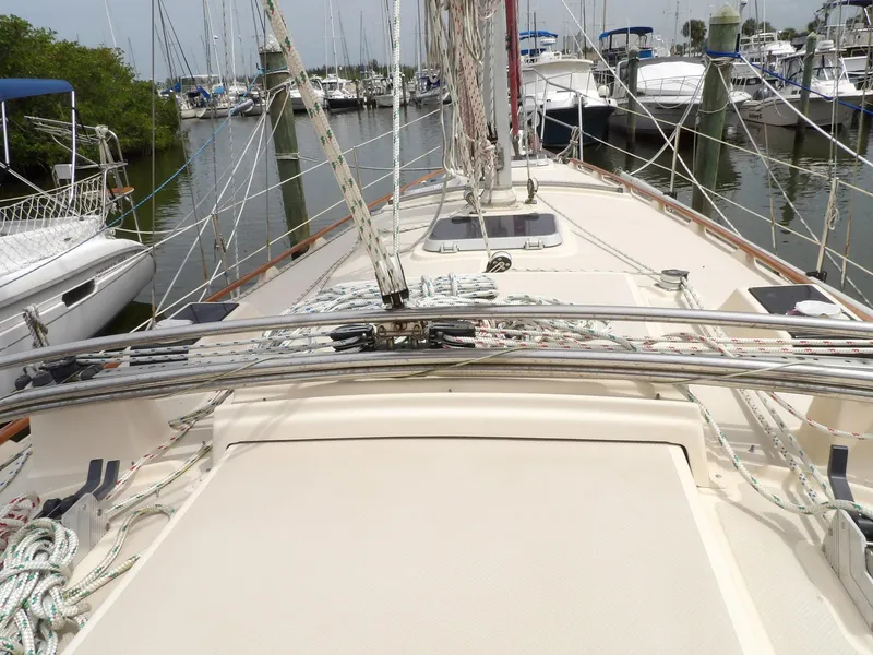 Slide: The Image of 1990 Island Packet 32 sailboat deck with rigging, docked in a marina. - 11