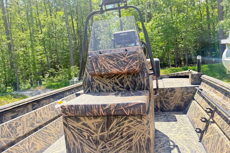 Slide: The Image of 2022 Lowe Roughneck 1860CC boat with camouflage design in a wooded area. - 11