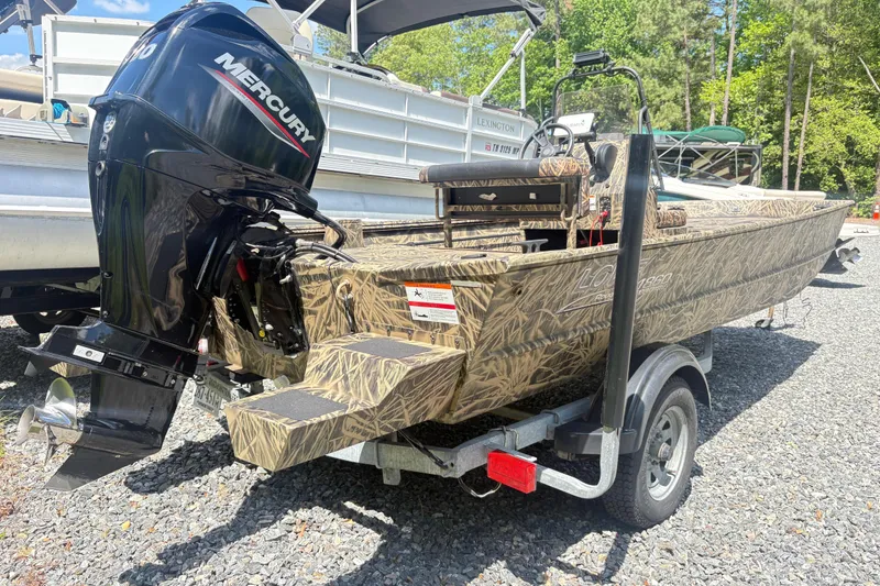 Slide: The Image of 2022 Lowe Roughneck 1860CC boat with Mercury engine on a trailer, outdoors. - 3