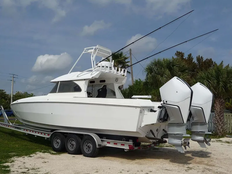 Slide: The Image of 1985 Wellcraft Scarab 34 boat on trailer with dual outboard motors. - 1