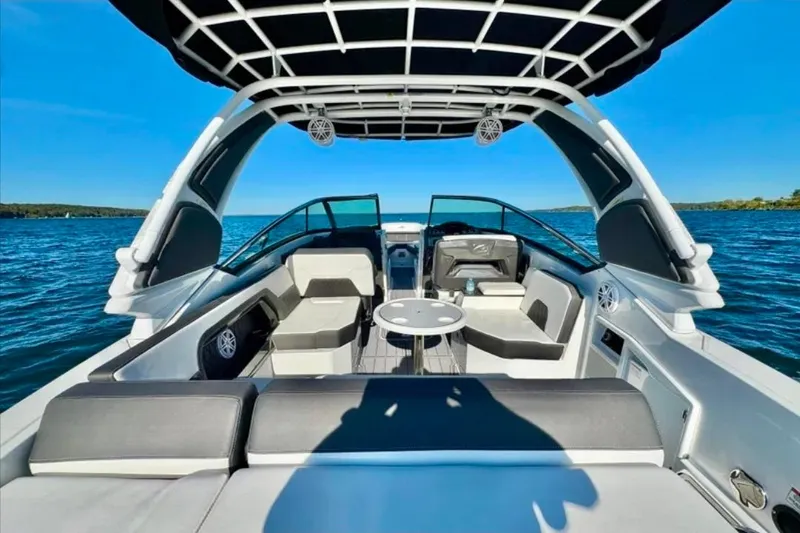 Slide: The Image of 2022 Monterey 305SS Super Sport boat interior with seating, table, and canopy on open water. - 3