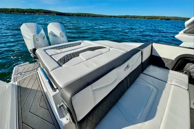 Slide: The Image of 2022 Monterey 305SS Super Sport boat with luxurious seating and dual Mercury engines on a lake. - 4