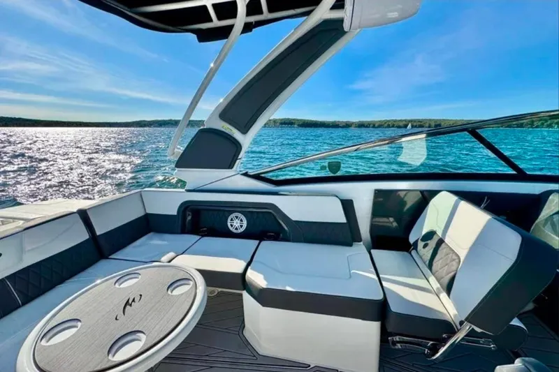Slide: The Image of 2022 Monterey 305SS Super Sport boat interior with seating and table on a sunny day. - 5
