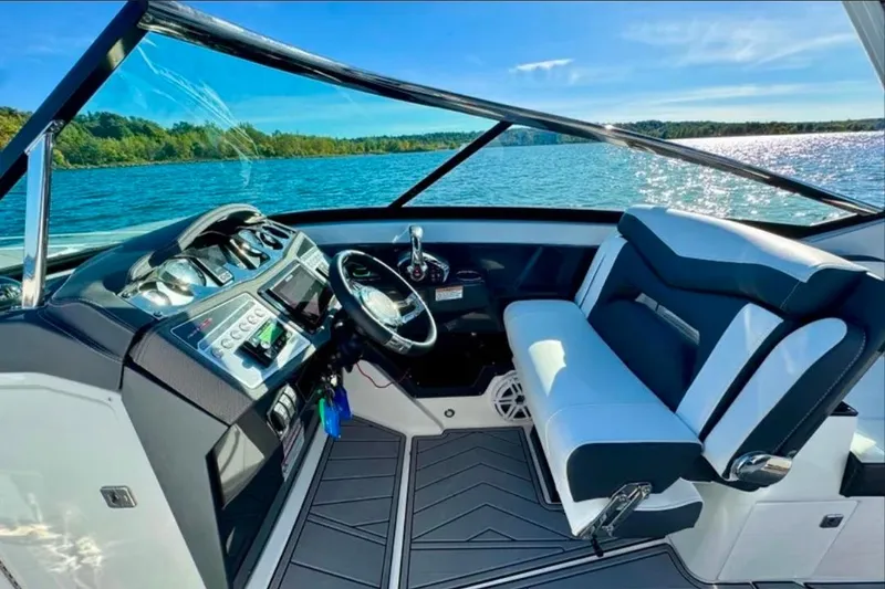 Slide: The Image of Cockpit view of 2022 Monterey 305SS Super Sport boat on a sunny lake. - 6