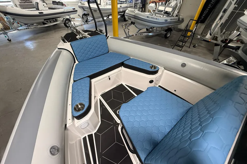 Slide: The Image of 2026 Highfield ADV7 boat interior with blue hexagonal-patterned seating and cup holders. - 21