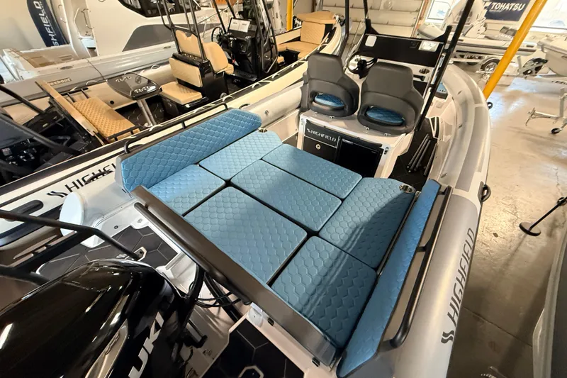 Slide: The Image of 2026 Highfield ADV7 boat with blue cushioned seating and dual helm chairs. - 26