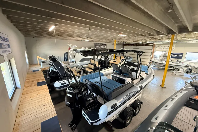 Slide: The Image of 2026 Highfield ADV7 boat in showroom with Suzuki engines, featuring modern design and seating. - 27