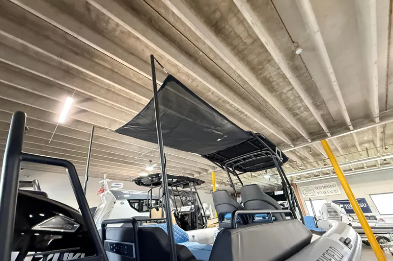 Slide: The Image of 2026 Highfield ADV7 boat with canopy, displayed indoors under industrial ceiling. - 35