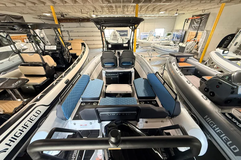 Slide: The Image of 2026 Highfield ADV7 boat interior with blue seating, displayed in a showroom. - 5