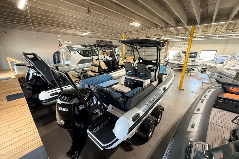 Slide: The Image of 2026 Highfield ADV7 boat in showroom with Suzuki 300 engine, surrounded by other boats. - 6
