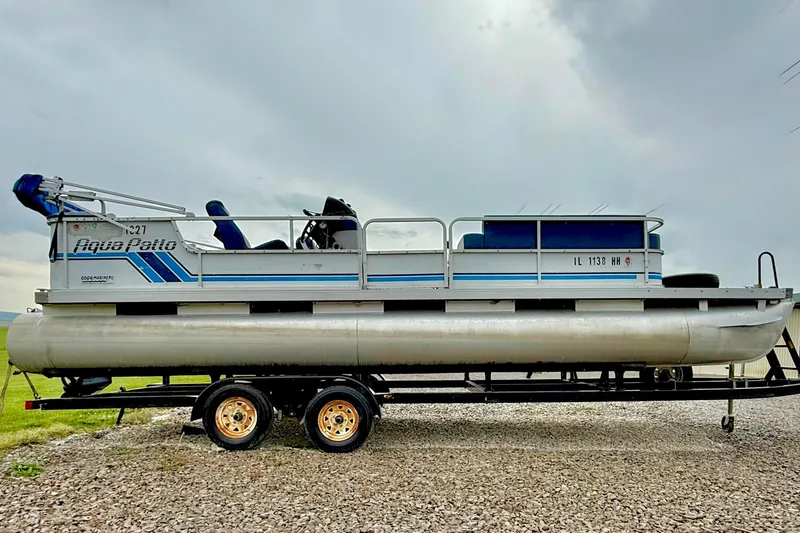 Slide: The Image of 1989 Godfrey Aqua Patio 2424 pontoon boat on trailer, parked on gravel. - 3