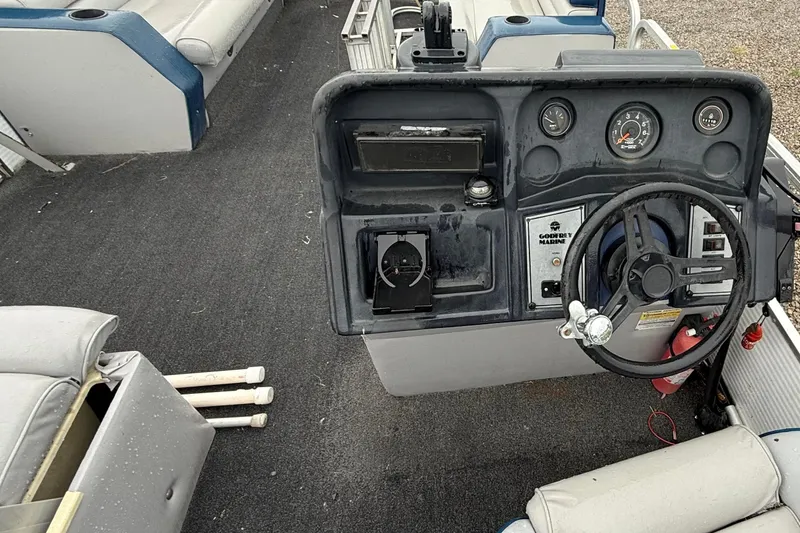 Slide: The Image of 1989 Godfrey Aqua Patio 2424 boat dashboard with steering wheel and gauges. - 7
