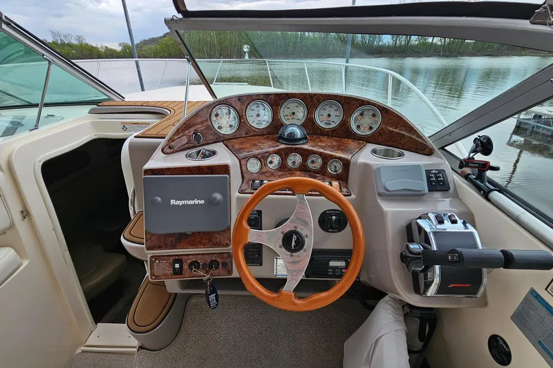 Slide: The Image of 2004 Rinker Fiesta Vee 312 boat dashboard with wood accents and steering wheel. - 12