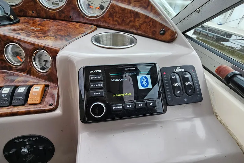 Slide: The Image of 2004 Rinker Fiesta Vee 312 dashboard with media center and control panel. - 14