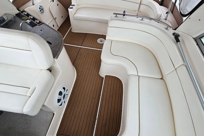 Slide: The Image of 2004 Rinker Fiesta Vee 312 boat interior with white seating and wood flooring. - 17