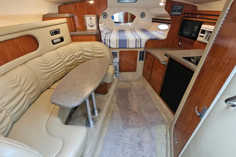 Slide: The Image of 2004 Rinker Fiesta Vee 312 cabin interior with seating, kitchenette, and bed. - 19