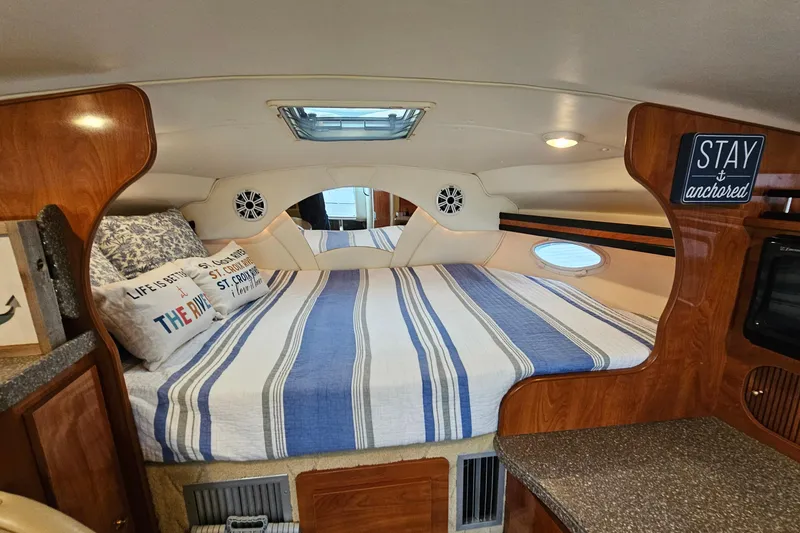 Slide: The Image of Cozy cabin interior of 2004 Rinker Fiesta Vee 312 with striped bedding and nautical decor. - 20