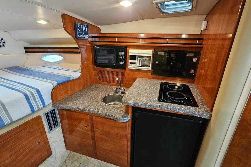 Slide: The Image of 2004 Rinker Fiesta Vee 312 cabin interior with kitchenette and bed. - 21