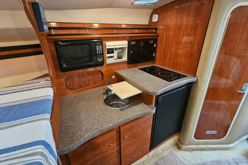 Slide: The Image of 2004 Rinker Fiesta Vee 312 boat interior with kitchenette, microwave, and stove. - 22
