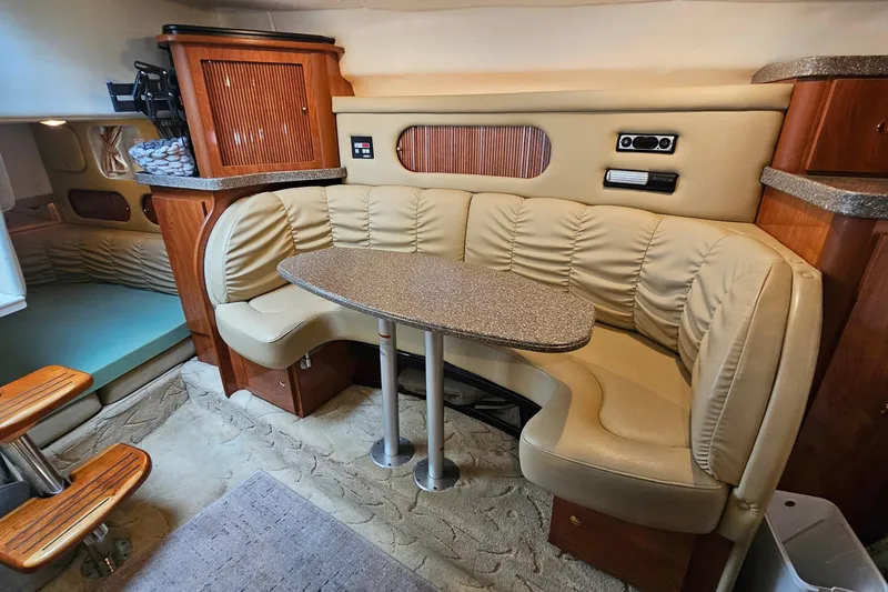 Slide: The Image of 2004 Rinker Fiesta Vee 312 cabin interior with beige seating and wooden accents. - 23