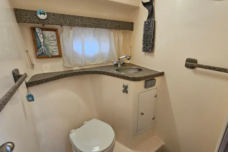Slide: The Image of 2004 Rinker Fiesta Vee 312 bathroom with sink, toilet, and decorative elements. - 26