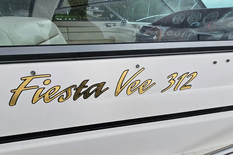 Slide: The Image of 2004 Rinker Fiesta Vee 312 boat with gold lettering on the side. - 32