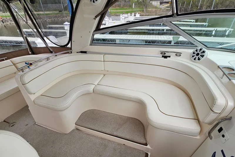 Slide: The Image of 2004 Rinker Fiesta Vee 312 boat interior with white leather seating and marina view. - 7