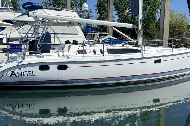 The Image of 2002 Hunter 386 sailboat docked in marina, reflecting on calm water. - 0