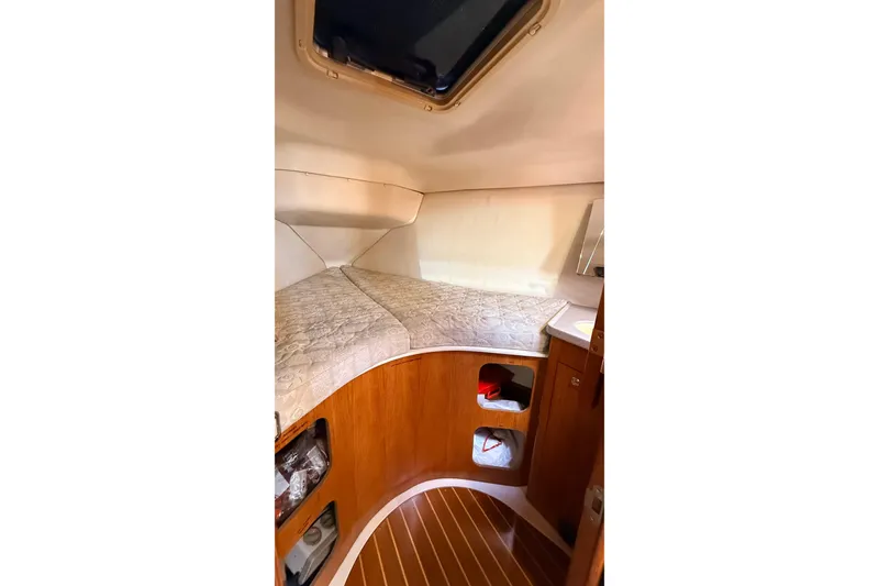 Slide: The Image of Cozy cabin interior of 2002 Hunter 386 sailboat with wooden accents and storage shelves. - 17