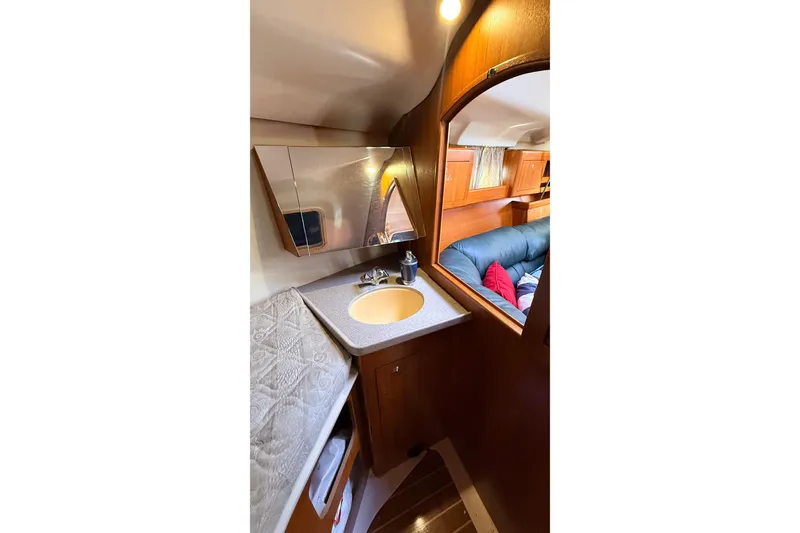 Slide: The Image of Interior of 2002 Hunter 386 yacht featuring a compact sink and cozy seating area. - 18