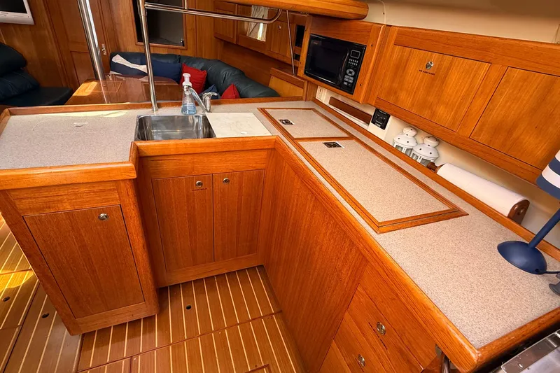Slide: The Image of Luxurious 2002 Hunter 386 yacht interior with wooden cabinetry and modern kitchen amenities. - 20