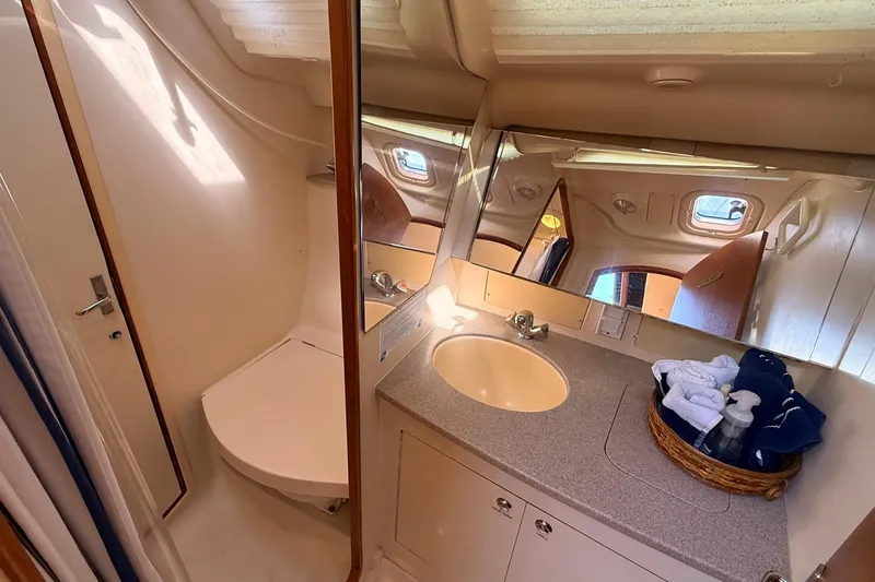 Slide: The Image of Interior of 2002 Hunter 386 yacht bathroom with sink, mirror, and storage. - 21