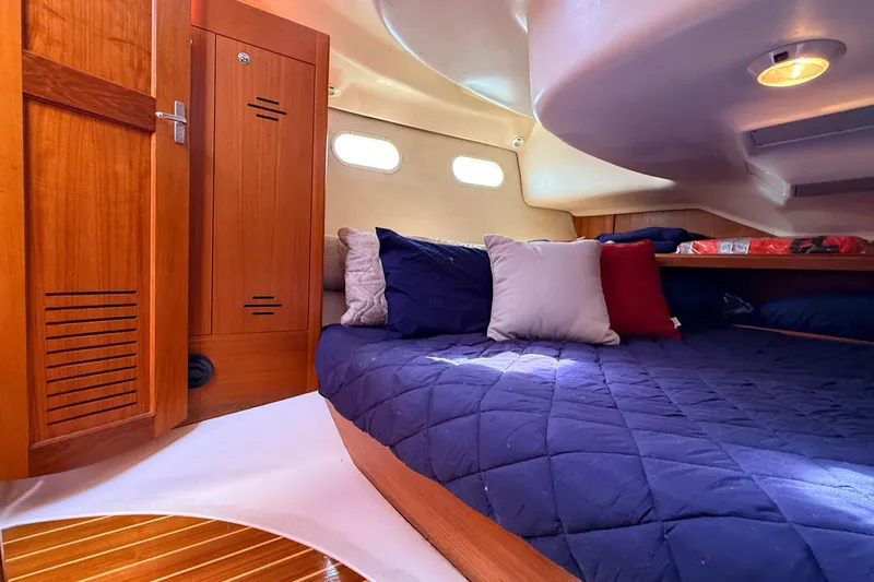 Slide: The Image of Cozy cabin interior of 2002 Hunter 386 sailboat with wooden accents and plush bedding. - 26
