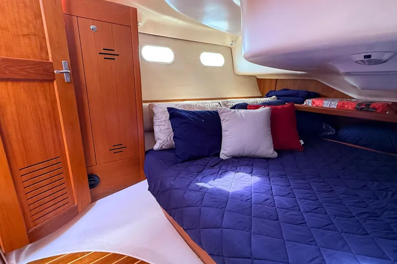 Slide: The Image of Cozy cabin interior of 2002 Hunter 386 sailboat with plush bedding and wooden cabinetry. - 27