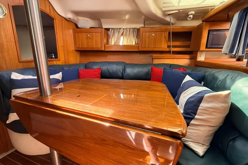 Slide: The Image of Cozy interior of 2002 Hunter 386 sailboat with wooden table and colorful cushions. - 3