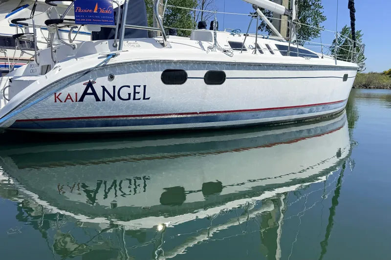 Slide: The Image of Hunter 386 sailboat from 2002 named "Kai Angel" docked on calm water. - 30
