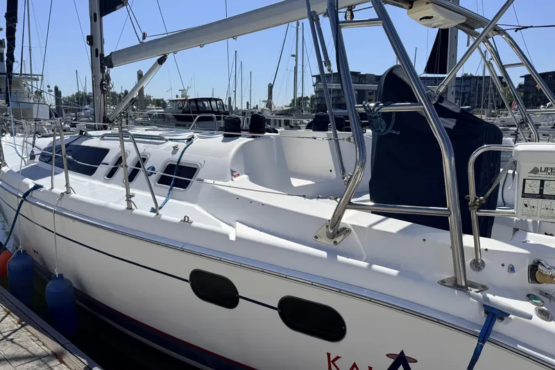 Slide: The Image of 2002 Hunter 386 sailboat docked at marina, featuring sleek white design and stainless steel railings. - 33
