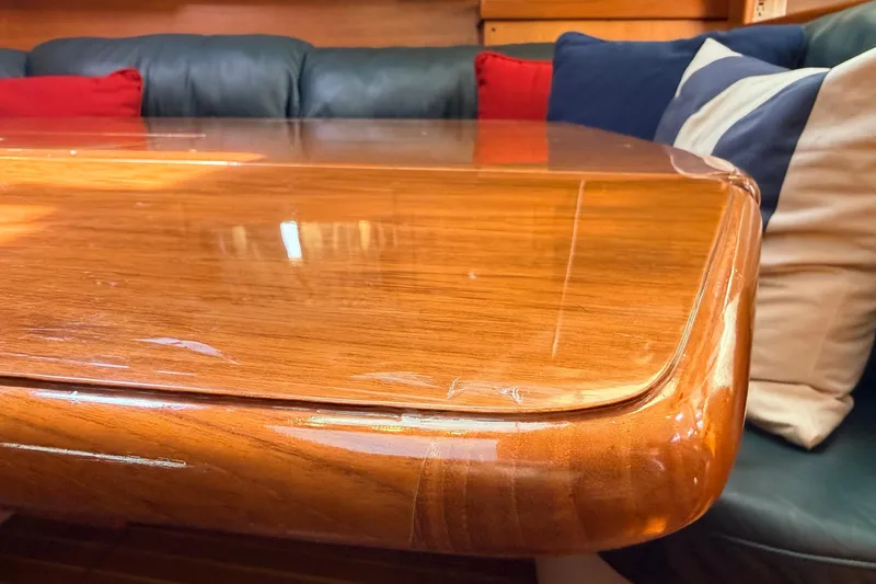 Slide: The Image of Polished wooden table in a 2002 Hunter 386 yacht interior with colorful cushions. - 5