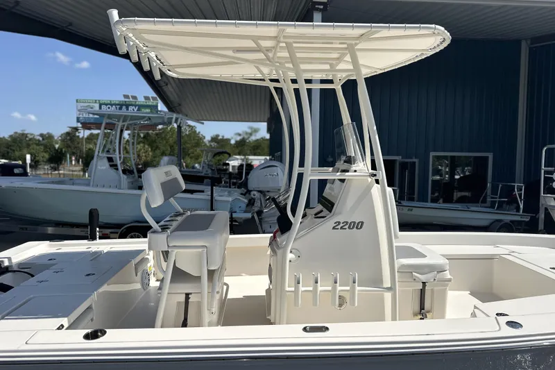 Slide: The Image of 2023 Pathfinder 2200 TRS boat with T-top and seating, displayed in a showroom. - 17