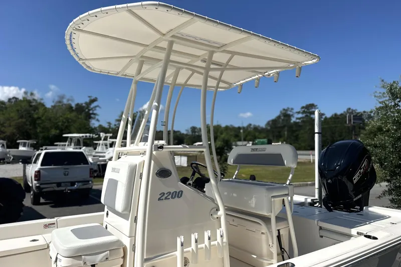 Slide: The Image of 2023 Pathfinder 2200 TRS boat with T-top and outboard motor in a sunny outdoor setting. - 23