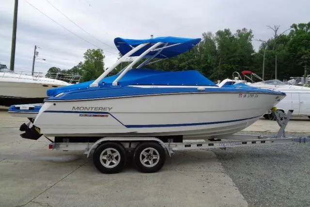 Slide: The Image of 2019 Monterey 218SS Super Sport boat on trailer with blue canopy and cover. - 2