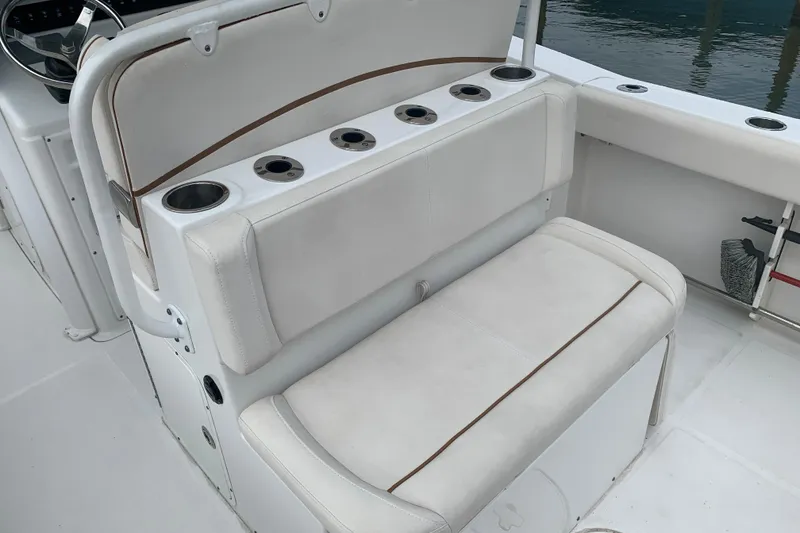 Slide: The Image of 2020 Sea Hunt Ultra 275 SE boat seating with cup holders and white upholstery. - 12