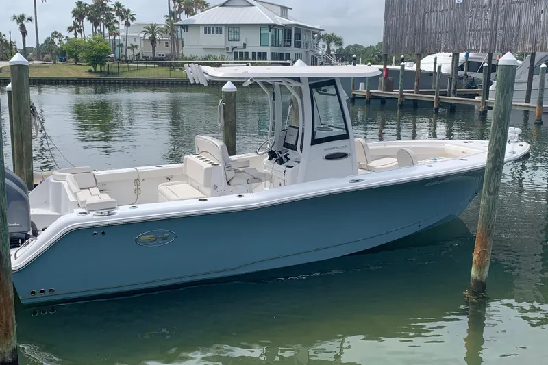 Slide: The Image of 2020 Sea Hunt Ultra 275 SE boat docked in a serene marina setting. - 2