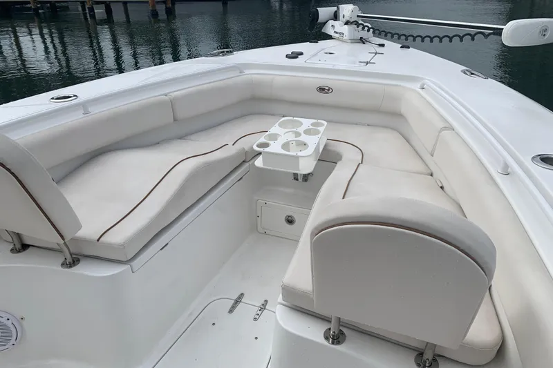 Slide: The Image of 2020 Sea Hunt Ultra 275 SE boat interior with cushioned seating and cup holders. - 9