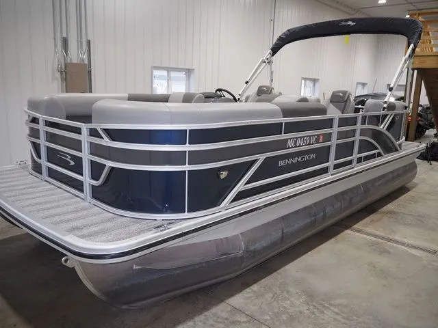 Slide: The Image of 2025 Bennington S Quad Bench 21 SSR pontoon boat parked indoors. - 3